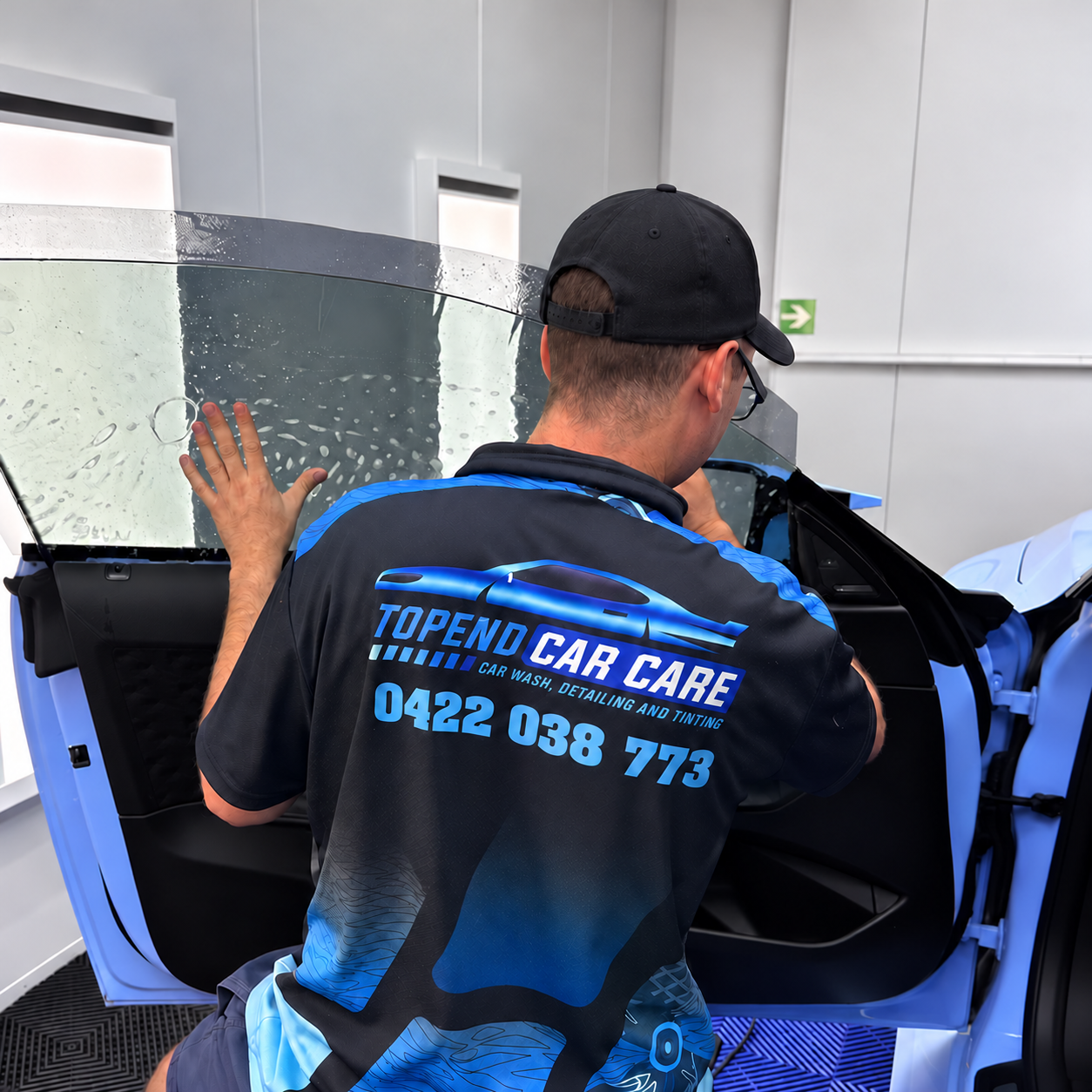 Topend Car Care technician installing automotive window tint at the Winnellie workshop